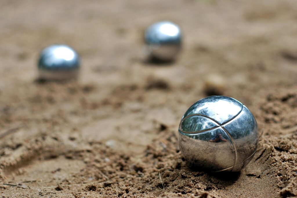 pexels-photo-273999-273999 Close-up of shiny petanque balls on a sandy beach. Perfect for outdoor and leisure themes.